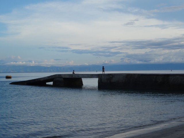 Local children play on the now empty pier